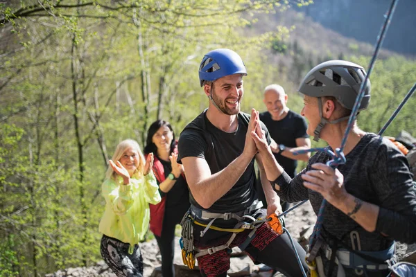 Gruppo di anziani con istruttore arrampicata rocce all'aperto in natura, stile di vita attivo. — Foto Stock