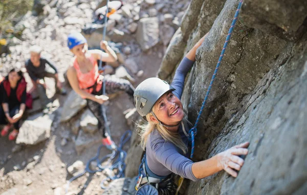 Ovanifrån av grupp av seniorer med instruktör klättring stenar utomhus i naturen, aktiv livsstil. — Stockfoto