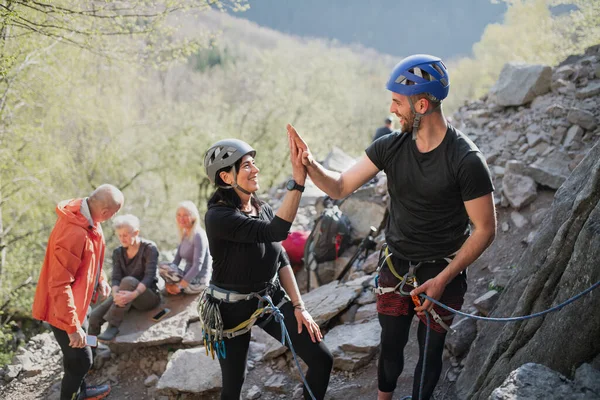 Group of seniors with instructor climbing rocks outdoors in nature, active lifestyle. — Stock Photo, Image