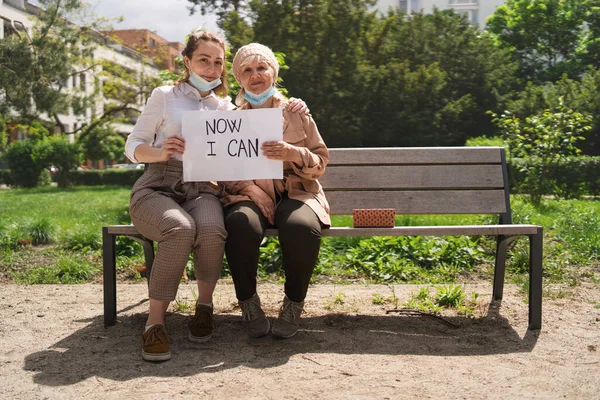 Portrait de jeune femme avec grand-mère à l'extérieur en ville, vie après la vaccination covid-19. — Photo