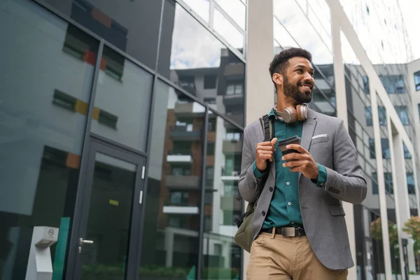 Vooraanzicht van de student wandelen in de voorkant van het gebouw buiten in de stad. — Stockfoto