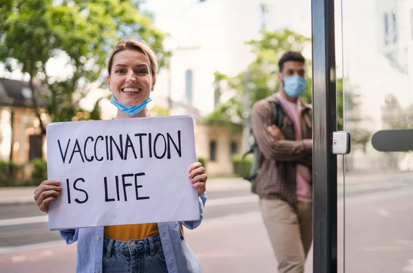 Portrait d'une jeune femme enlevant son masque à l'extérieur en ville, vie après la vaccination covid-19. — Photo