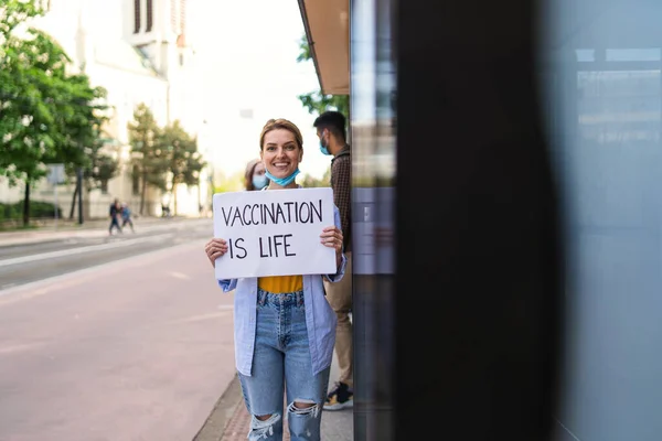 Portrait d'une jeune femme enlevant son masque à l'extérieur en ville, vie après la vaccination covid-19. — Photo