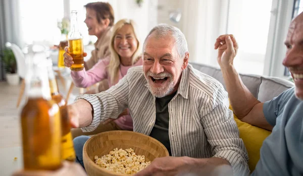 Grupo de amigos mayores viendo películas en interiores, fiestas, reuniones sociales y divertirse concepto. — Foto de Stock