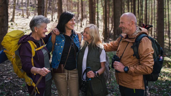 Seniorengruppe wandert draußen im Wald in der Natur und blickt in die Kamera. — Stockfoto