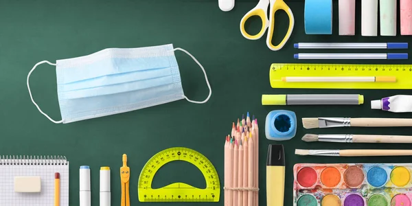 Flat lay top view of face mask and school supplies, back to school and coronavirus concept. — Stock Photo, Image