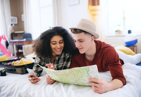 Glada unga par förbereder och packar för sommarsemester hemma, planerar. — Stockfoto