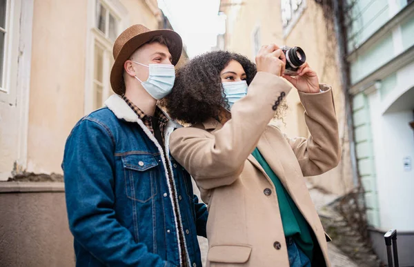 Jovens turistas casal tirar fotografias na rua na cidade velha, conceito coronavírus. — Fotografia de Stock