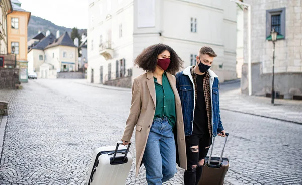 Joven pareja de turistas con equipaje caminando por las calles del casco antiguo, concepto coronavirus. — Foto de Stock