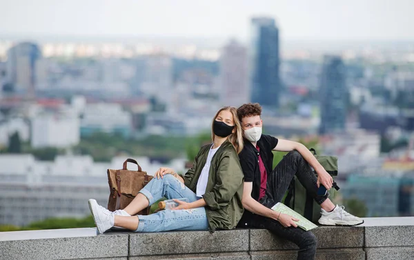Молода пара мандрівників з картою, дивлячись на камеру в місті у відпустці, концепція коронавірусу . — стокове фото