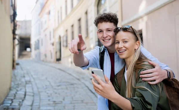 Jovens viajantes casal usando smartphone na cidade de férias, passeios. — Fotografia de Stock