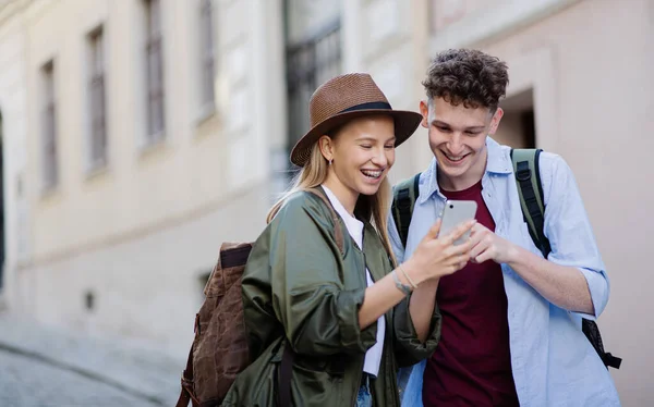 Jonge koppel reizigers met smartphone in de stad op vakantie, sightseeing. — Stockfoto