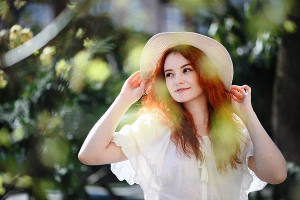Πορτρέτο της νεαρής γυναίκας με καπέλο στέκεται σε εξωτερικούς χώρους στην πόλη το καλοκαίρι. — Φωτογραφία Αρχείου