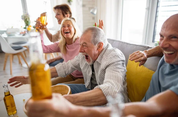Grupo de amigos mayores viendo películas en interiores, fiestas, reuniones sociales y divertirse concepto. — Foto de Stock