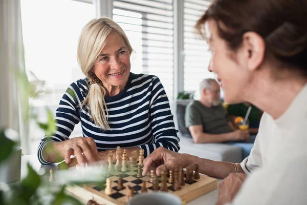 Grupo de amigos mayores jugando juegos de mesa en interiores, fiesta y concepto de reunión social. — Foto de Stock