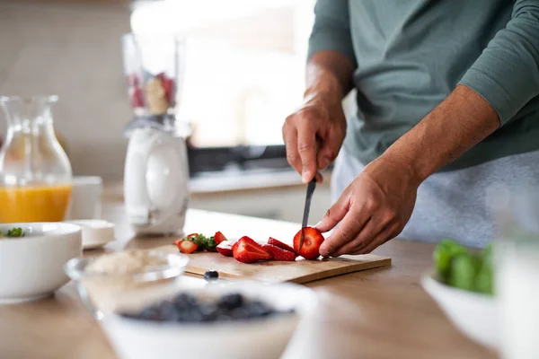 Oigenkännlig man förbereder smoothie inomhus, hälsosam kost koncept. — Stockfoto