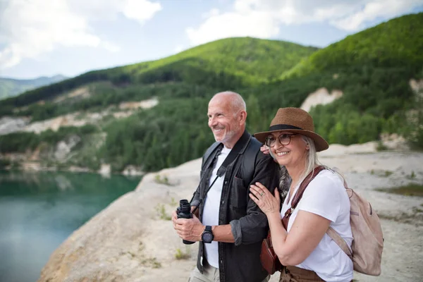 Feliz pareja de ancianos en viaje de senderismo en vacaciones de verano, mirando el paisaje. —  Fotos de Stock