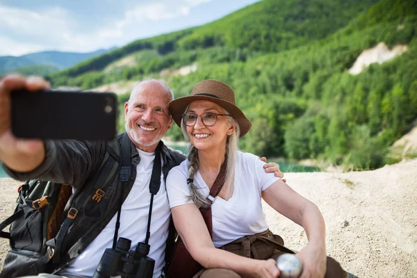 Szczęśliwa para seniorów na wycieczce na wakacje, biorąc selfie. — Zdjęcie stockowe