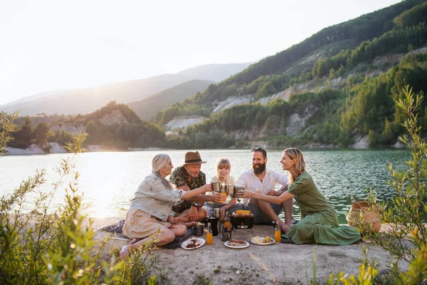 Happy multigeneration family on summer holiday trip, barbecue by lake. — Stock Photo, Image