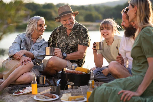 快乐的多代家庭在暑假旅行，在湖边烧烤. — 图库照片