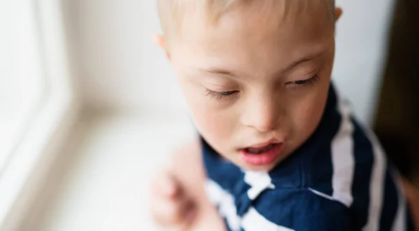 Close-up portrait of down syndrome boy indoors at home. Copy space. — Stock Photo, Image