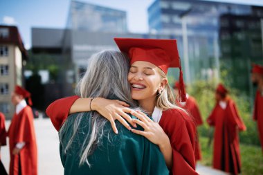 Açık havada kutlama yapan neşeli üniversite öğrencisinin portresi, mezuniyet konsepti..