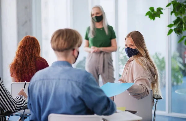 Universitaire studenten met leraar die binnen studeert, coronavirus en terug naar normaal concept. — Stockfoto