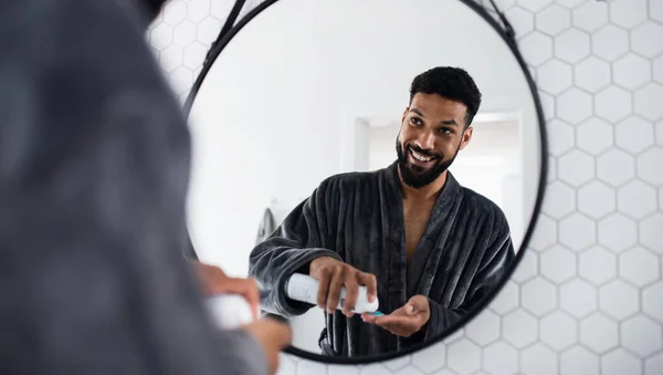 Young man using shaving gel indoors at home, morning or evening routine concept. — Stock Photo, Image