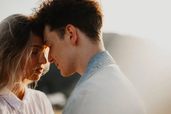 Pareja joven en un paseo por la naturaleza al atardecer en el campo, abrazos. —  Fotos de Stock