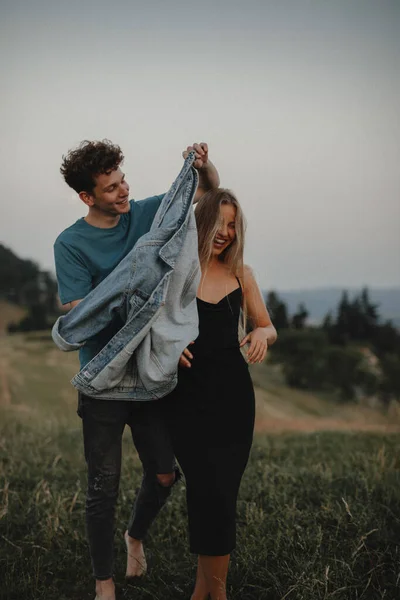 Jong stel wandelen in de natuur op het platteland, lachen. — Stockfoto