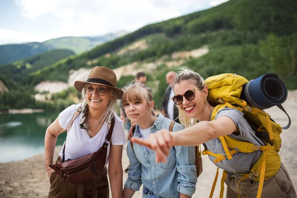 Família multigeracional feliz em uma viagem de caminhada nas férias de verão, apontando para algo. — Fotografia de Stock