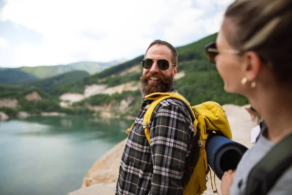 Happy mature couple on hiking trip on summer holiday, walking by lake. — Stock Photo, Image