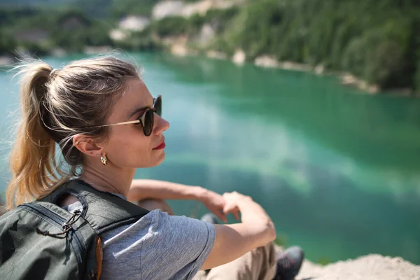 Midden volwassen vrouw toerist op wandeltocht op zomervakantie, rust door het meer. — Stockfoto