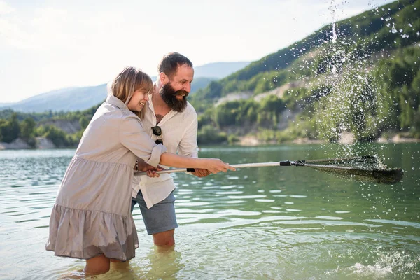 Ευτυχισμένοι preteen κορίτσι και ο πατέρας με δίχτυ ψαρέματος στις καλοκαιρινές διακοπές στη λίμνη. — Φωτογραφία Αρχείου