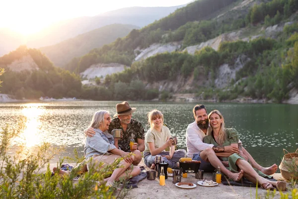 Feliz familia multigeneración en viaje de vacaciones de verano, barbacoa junto al lago al atardecer. —  Fotos de Stock