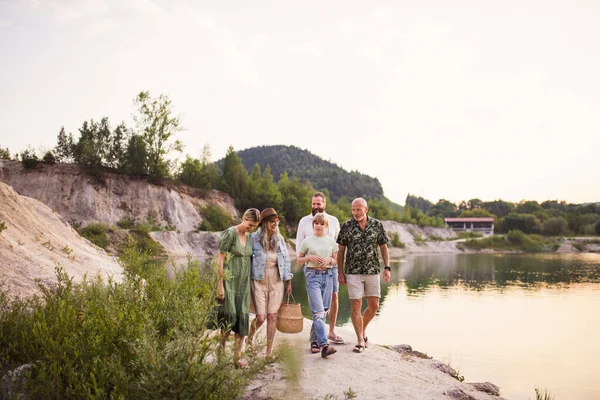 Feliz familia multigeneracional en vacaciones de verano, caminando por el lago. —  Fotos de Stock