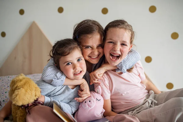 Porträtt av tre flickor systrar inomhus hemma, tittar på kameran. — Stockfoto