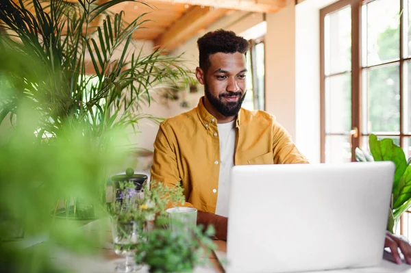 Jongeman met laptop en koffie werkt binnen, home office concept. — Stockfoto