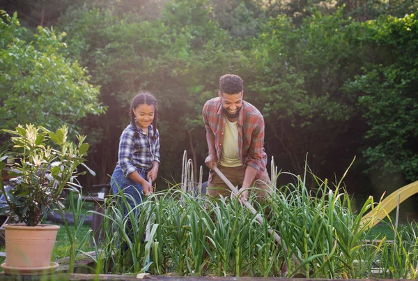 Ayah muda yang bahagia dengan anak kecil bekerja di luar rumah di halaman belakang, konsep berkebun. — Stok Foto