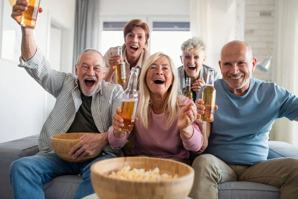 Grupo de amigos seniores assistindo filme em casa, festa, reunião social e se divertindo conceito. Fotografias De Stock Royalty-Free