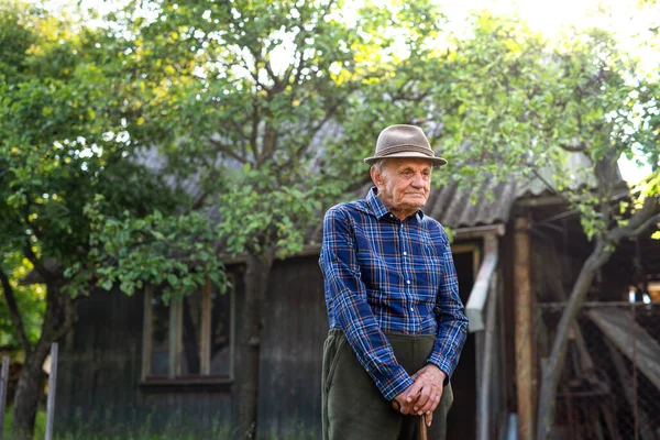 Retrato de homem idoso em pé ao ar livre no jardim, descansando. — Fotografia de Stock