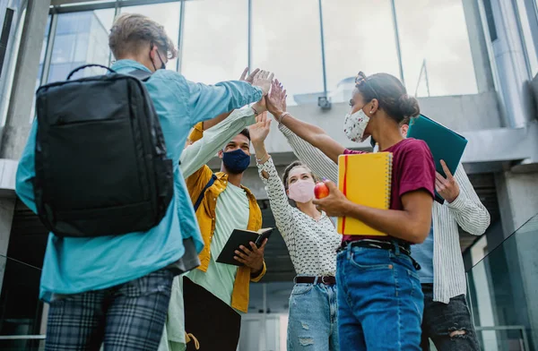 Universitetsstudenter stående och hälsning inomhus, coronavirus och tillbaka till det normala konceptet. — Stockfoto