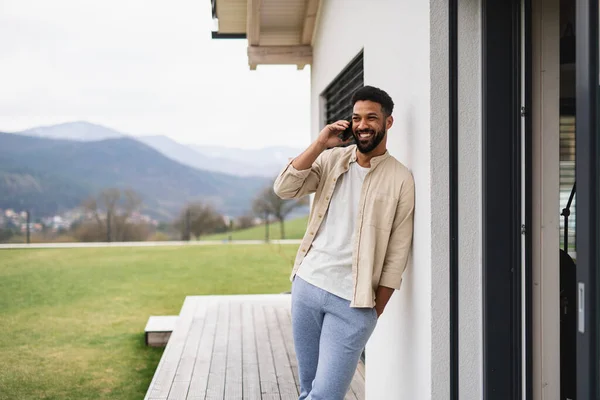 Ung man student med smartphone utomhus på uteplats hemma, ringa ett samtal. — Stockfoto