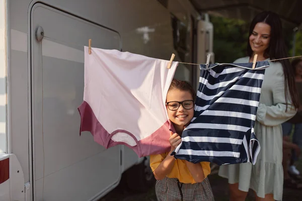 Matka s dcerou visí oblečení na autě venku v kempu, karavan rodinný výlet. — Stock fotografie