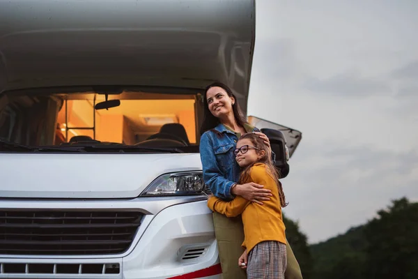 黄昏时分，母亲带着女儿站在露营地的汽车旁，这是大篷车家族的假日旅行. — 图库照片