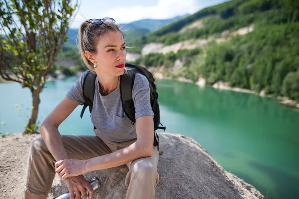 Midden volwassen vrouw toerist op wandeltocht op zomervakantie, rust door het meer. — Stockfoto