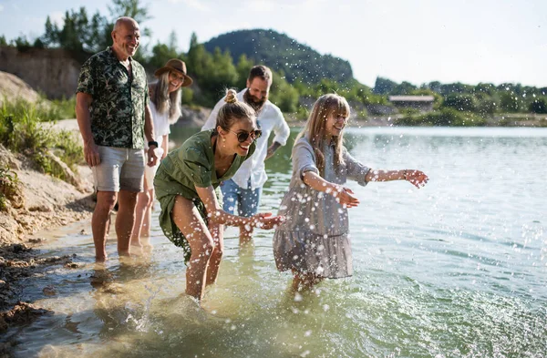 Feliz familia multigeneración en el paseo por el lago en las vacaciones de verano, divertirse en el agua. —  Fotos de Stock