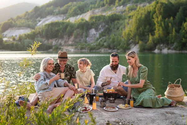 Szczęśliwa wielopokoleniowa rodzina na wakacyjnej wycieczce, grill nad jeziorem. — Zdjęcie stockowe