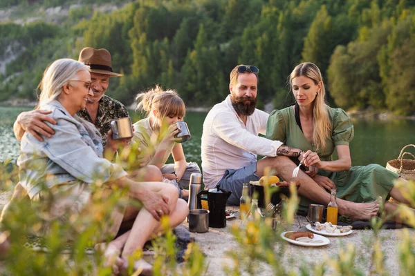 Bonne famille multigénération en voyage de vacances d'été, barbecue au bord du lac. — Photo