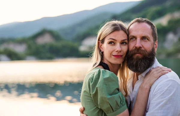 Gelukkig volwassen paar in liefde knuffelen in de natuur, kijken naar camera. — Stockfoto